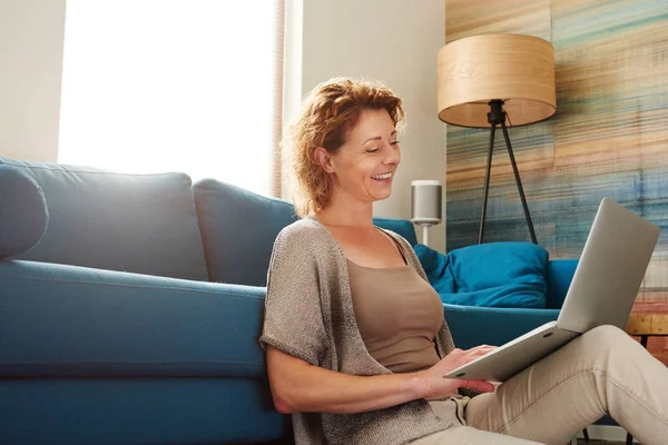 Femme dans un appartement confortable avec ordinateur portable — Photo