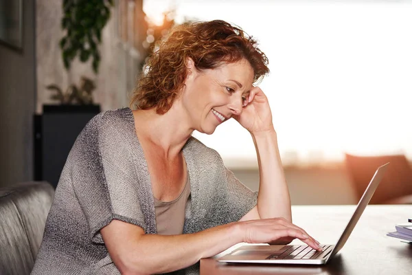 Kvinnan lutar sig på bord med laptop — Stockfoto