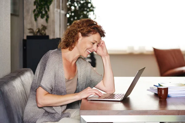 Vrouw leunend op tafel met laptop — Stockfoto