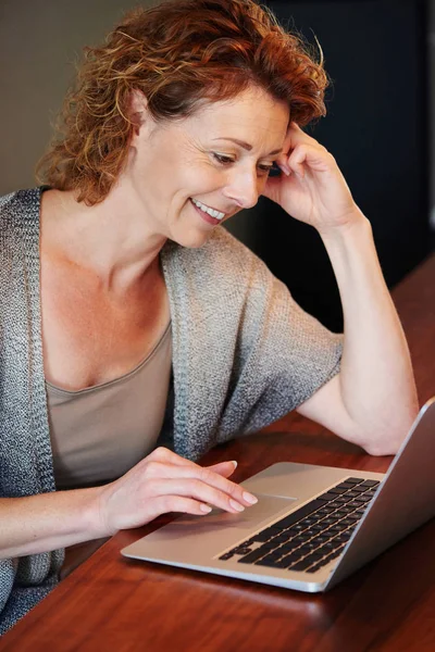 Kvinnan lutar sig på bord med laptop — Stockfoto
