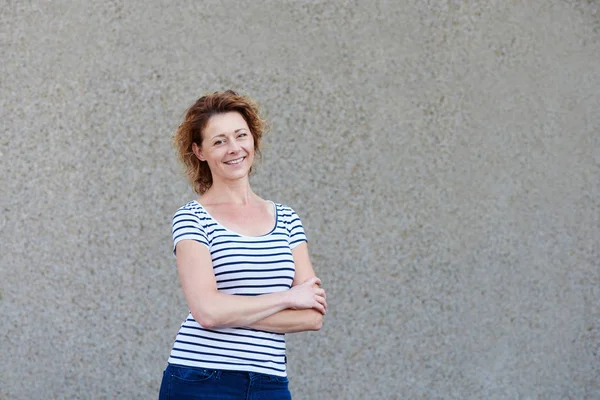 Woman standing by wall outside — Stock Photo, Image