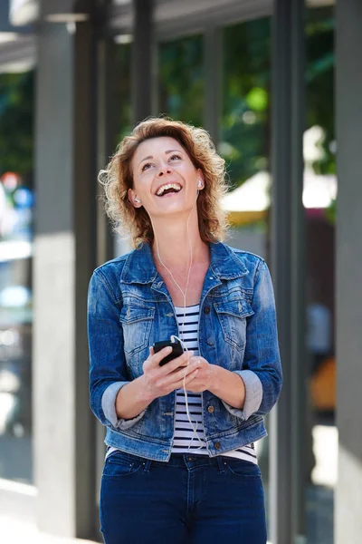 Lachende vrouw met telefoon in stad — Stockfoto