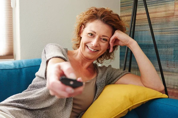 Vrouw bedrijf afstandsbediening — Stockfoto