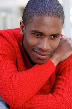 Çapraz silahlarla oturan adam