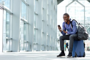 Bagaj ve cep telefonu ile oturan işadamı