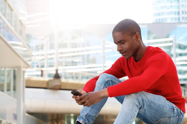 Man sitting outside using phone — Stock Photo, Image