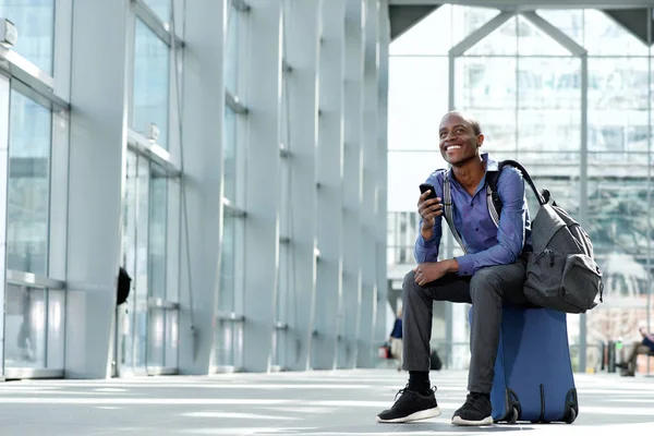 Geschäftsmann sitzt mit Gepäck und Handy — Stockfoto
