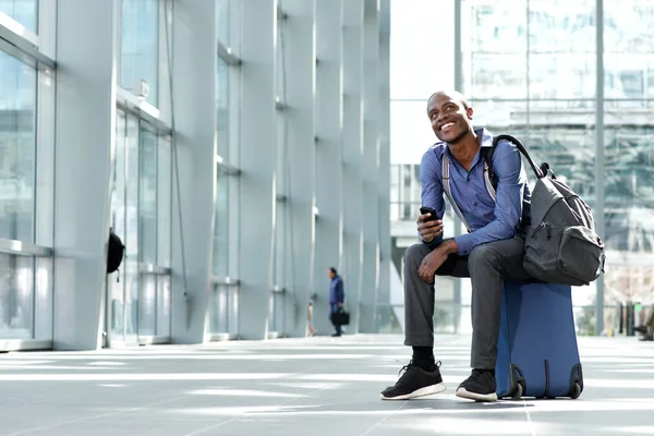 Geschäftsmann sitzt mit Gepäck und Handy — Stockfoto