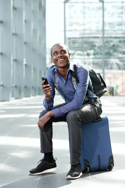 Geschäftsmann sitzt mit Gepäck und Handy — Stockfoto