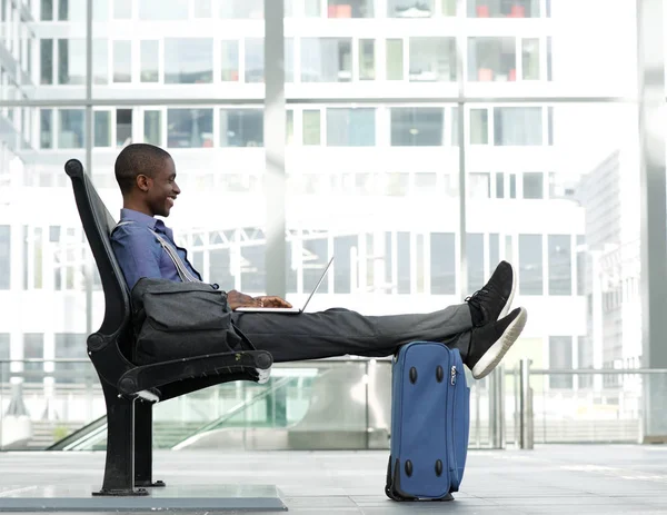 Empresario sentado con portátil en la estación — Foto de Stock