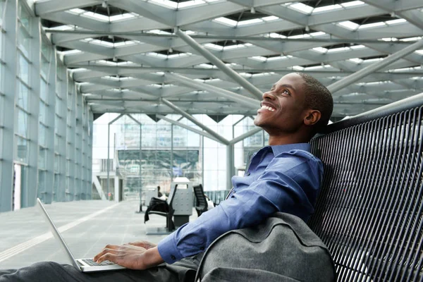 Geschäftsmann sitzt mit Laptop am Bahnhof — Stockfoto