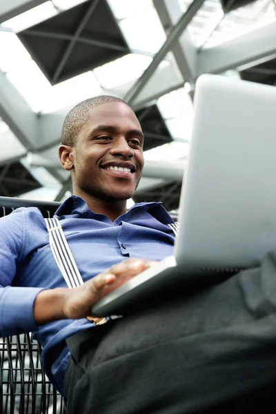Homme d'affaires joyeux assis avec ordinateur portable — Photo