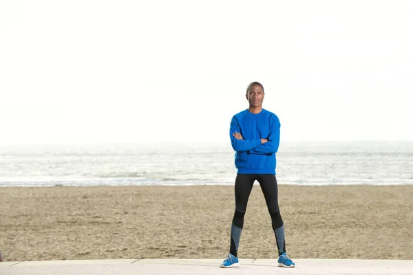 Sportig kille står på stranden — Stockfoto