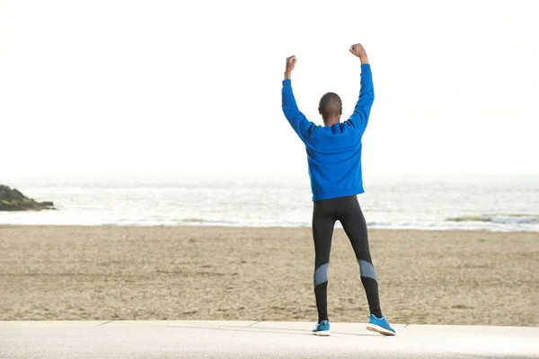 Sportig kille står på stranden — Stockfoto