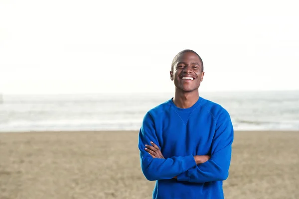 Hombre con sudadera azul en la playa —  Fotos de Stock