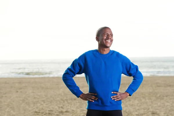 Мужчина в синей толстовке на пляже — стоковое фото