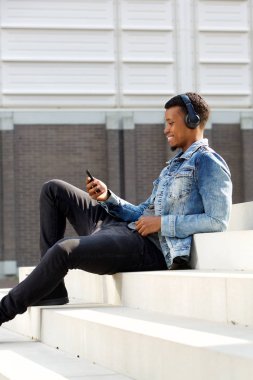 Telefon ile merdivenlerde oturan adam 