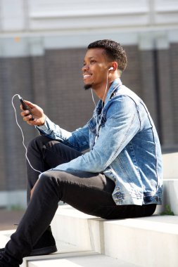 Adam cep telefonu ve kulaklık dışında