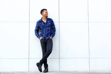 Adam ayakta mavi tişört giyiyor.