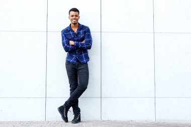 Adam ayakta mavi tişört giyiyor.