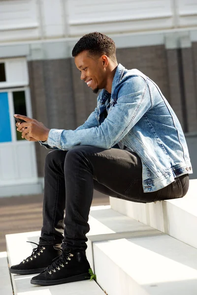 Telefon ile merdiven üzerinde oturan adam — Stok fotoğraf