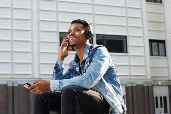 Telefon ile merdivenlerde oturan adam 