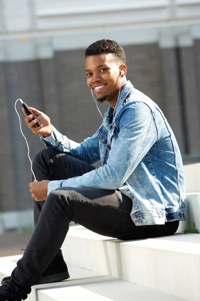 Muž s mobilní telefon a sluchátka mimo — Stock fotografie