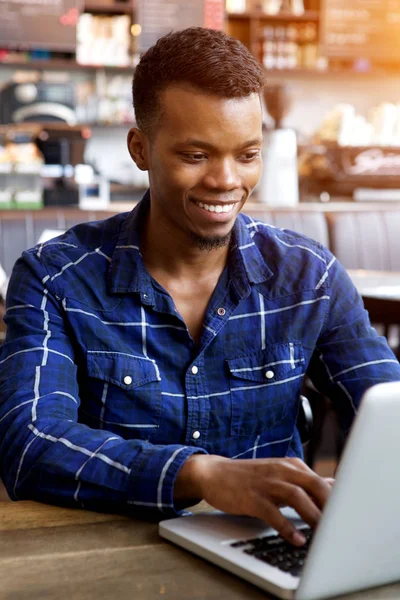 Man sitting in cafe working on laptop