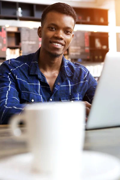 Hombre sentado en la cafetería trabajando en el ordenador portátil — Foto de Stock