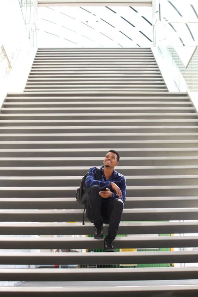 Мужчина, сидящий на лестнице по телефону — стоковое фото