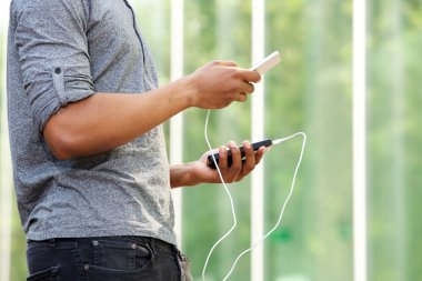 harici pil ve telefonu tutan adam