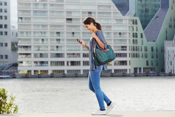 Vrouw lopen en het gebruik van de telefoon — Stockfoto