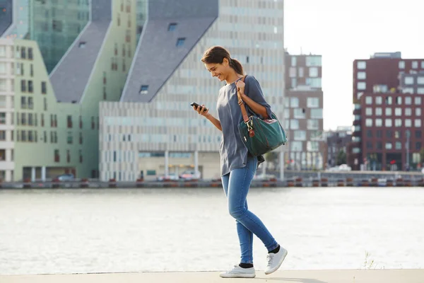 Vrouw lopen en het gebruik van de telefoon — Stockfoto