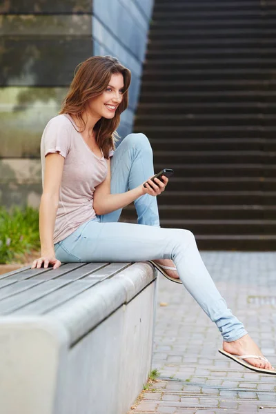 Woman sitting on bench outdoors — Stock Photo, Image
