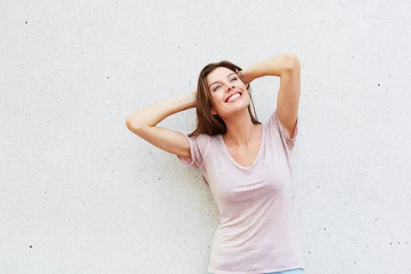 Young lady smiling against wall — Stock Photo, Image
