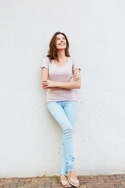 Jeune femme appuyée contre le mur — Photo