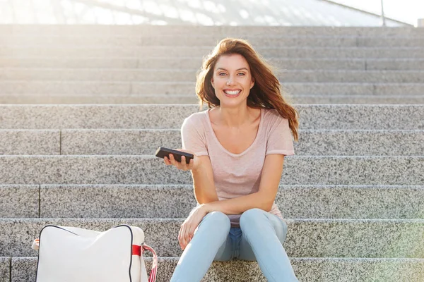 Žena sedí na schodech s chytrý telefon — Stock fotografie