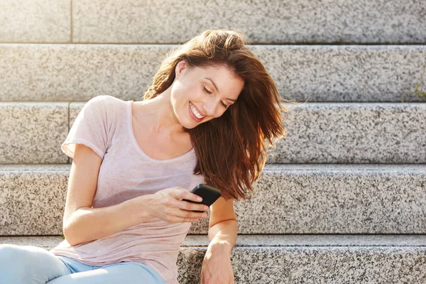 Adımlar ile akıllı telefon üzerinde oturan kadın — Stok fotoğraf