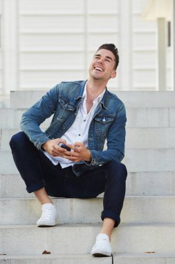 Mobile ile adımlar üzerinde oturan adam