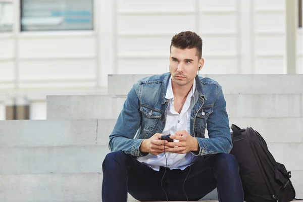 Uomo seduto su gradini con cellulare — Foto Stock