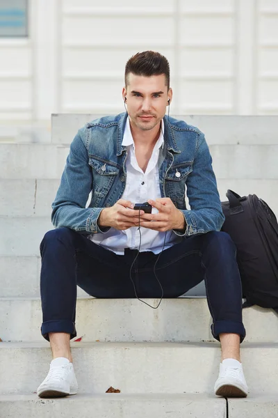 Homem sentado em degraus com celular — Fotografia de Stock