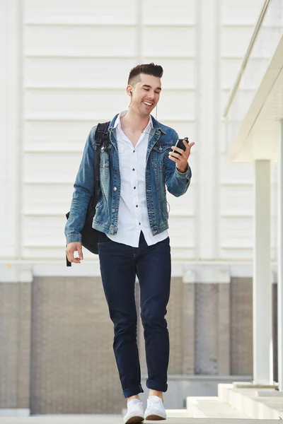 Hombre caminando con móviles y auriculares —  Fotos de Stock