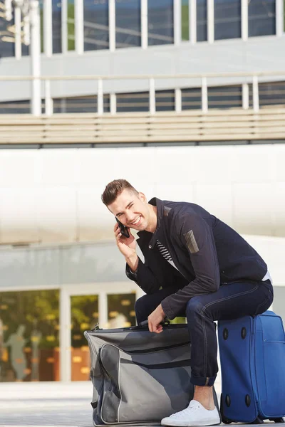 Ο άνθρωπος στην τηλεφωνική κλήση στο σταθμό με αποσκευές — Φωτογραφία Αρχείου