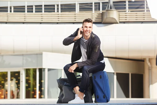 Uomo al telefono alla stazione con i bagagli — Foto Stock