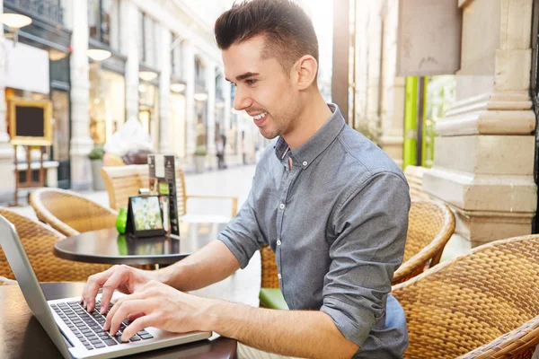 Человек сидит в кафе с ноутбуком — стоковое фото