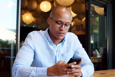 masada oturan ve cep telefonu kullanarak iş adamı