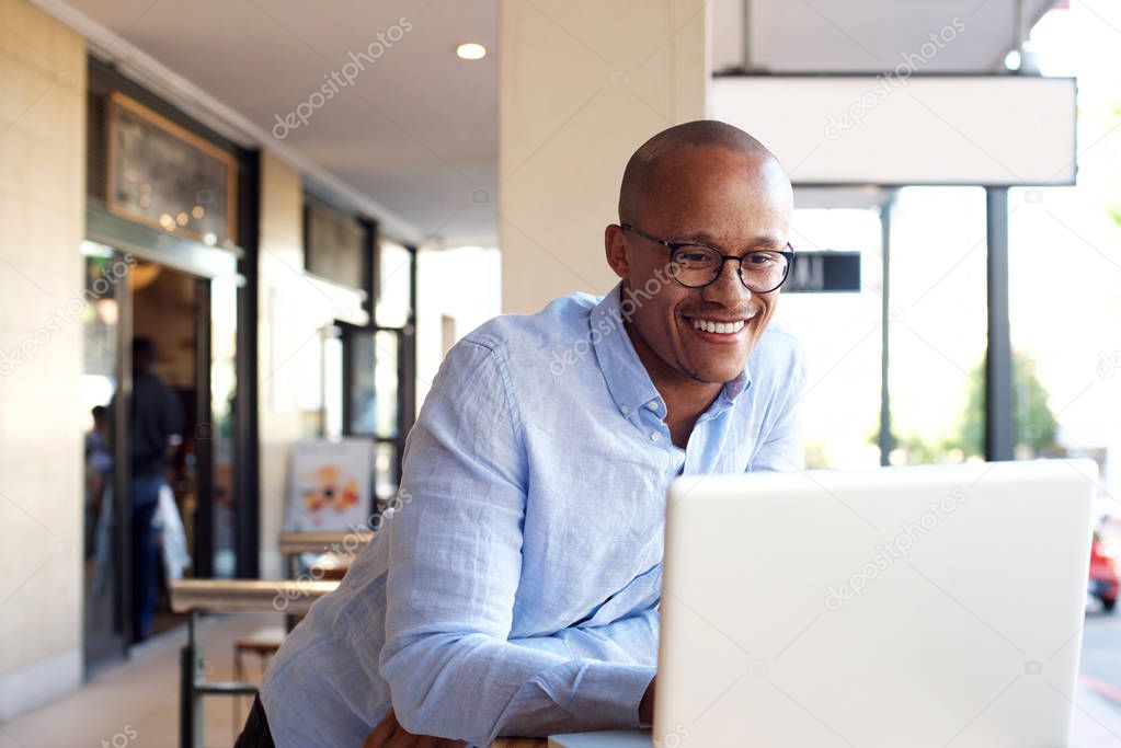 businessman working with laptop and leaning on table