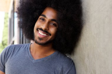 Sakal ve afro duvara yaslanmış olan adam