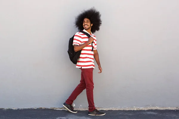 Student met zak lopen door muur — Stockfoto