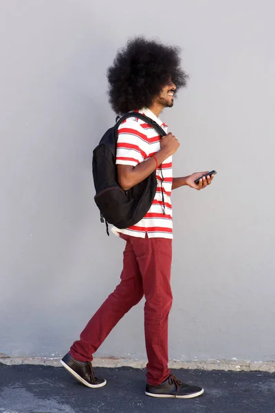 Homem andando com saco e telefone celular — Fotografia de Stock